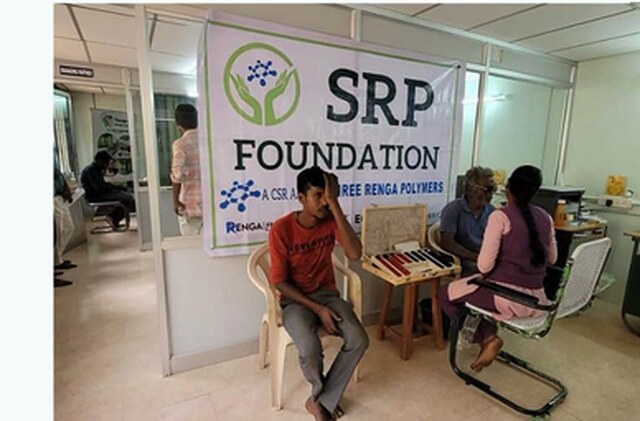 Employees wait at an SRP Foundation health camp banner at the Puliyur unit.