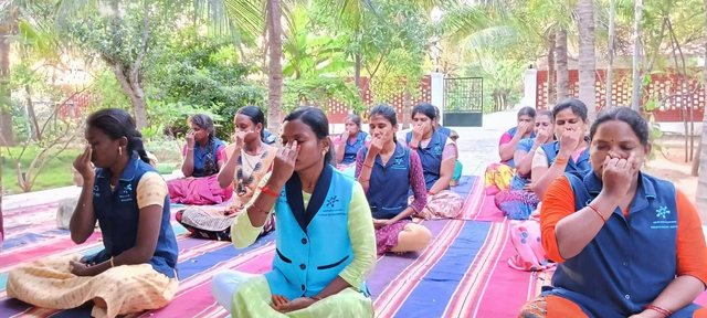 A group practises a breathing exercise outdoors during an SRP Foundation wellness session.